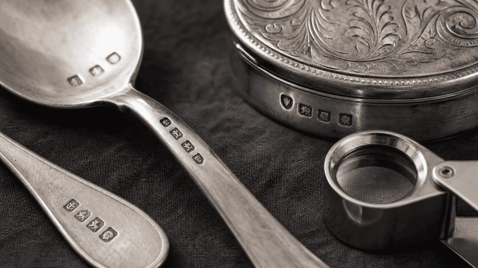 Silver hallmarks identification close-up of sterling marks on antique spoons and a small silver box